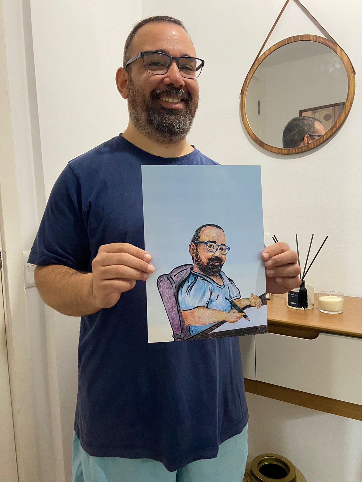 André Nunes segurando um autorretrato desenhado à mão